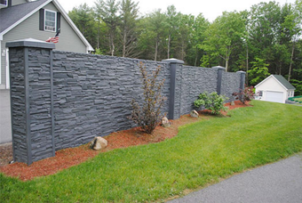 A gray decorative concrete wall separates a home from a road in Lehigh Valley